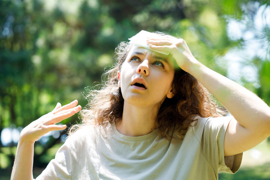 Vrouw veegt bezweet voorhoofd af tegen hittestress